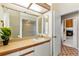Bathroom featuring a large mirror, a sink, and a view into a room with a fireplace at 3014 Ashland Ter, Clearwater, FL 33761