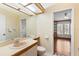 Bathroom with a large mirror and sink featuring patterned wallpaper at 3014 Ashland Ter, Clearwater, FL 33761