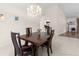 Elegant dining area with a chandelier above a wooden table and seating for four, with a kitchen view at 3014 Ashland Ter, Clearwater, FL 33761
