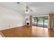 Sunlit living room with wood floors, ceiling fan, sliding glass doors to the pool and backyard at 3014 Ashland Ter, Clearwater, FL 33761