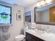 Bathroom featuring a stained glass window, vanity with marble top, framed mirror, and brushed nickel faucet at 3182 Windmoor N Dr, Palm Harbor, FL 34685