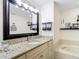 Modern bathroom features granite countertops, decorative vanity, and soaking tub at 3182 Windmoor N Dr, Palm Harbor, FL 34685