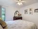 Bright bedroom features a ceiling fan, closet, and decorative touches like framed art and patterned bedding at 3182 Windmoor N Dr, Palm Harbor, FL 34685