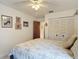 Bright bedroom showcases a ceiling fan and closet, complemented by decorative framed artwork at 3182 Windmoor N Dr, Palm Harbor, FL 34685