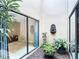 Exterior courtyard area, with plants and stone ground cover with a large glass sliding doors at 3182 Windmoor N Dr, Palm Harbor, FL 34685