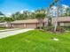 Charming home exterior featuring a well-manicured lawn and two-car garage at 3182 Windmoor N Dr, Palm Harbor, FL 34685