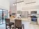Open concept kitchen with stainless steel appliances, granite island, and view to the lanai at 3182 Windmoor N Dr, Palm Harbor, FL 34685