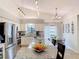 Bright kitchen with white cabinets, stainless steel appliances, and large granite island at 3182 Windmoor N Dr, Palm Harbor, FL 34685