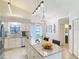Open kitchen with island, white cabinets, stainless appliances, and adjacent breakfast nook at 3182 Windmoor N Dr, Palm Harbor, FL 34685