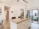Spacious kitchen island with white cabinets and granite countertops, access to a private patio at 3182 Windmoor N Dr, Palm Harbor, FL 34685