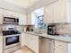 Well-equipped kitchen with stainless steel appliances, stone backsplash, and modern fixtures at 3182 Windmoor N Dr, Palm Harbor, FL 34685