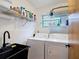 Bright laundry room with washer, dryer, sink and ample shelving for storage solutions at 3182 Windmoor N Dr, Palm Harbor, FL 34685