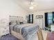 Open main bedroom features a ceiling fan, large windows and a comfortable seating area near the vanity at 3182 Windmoor N Dr, Palm Harbor, FL 34685