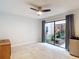 Bright room with tiled floors and a sliding glass door looking out to an enclosed courtyard at 3182 Windmoor N Dr, Palm Harbor, FL 34685