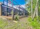 Enjoy this large screened in porch that looks out onto the lush lawn and native Florida landscaping at 3182 Windmoor N Dr, Palm Harbor, FL 34685
