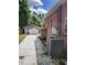 Side yard view of a brick home featuring detached garage and well-maintained landscaping at 3607 N 13Th St, Tampa, FL 33605