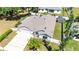 A stunning aerial view showcasing the home with an attached 2-car garage, extended driveway, and manicured landscaping at 37673 Dixie Ave, Dade City, FL 33525