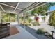 A covered patio overlooks a serene backyard featuring a decorative rock waterfall, mature trees and lush landscaping at 37673 Dixie Ave, Dade City, FL 33525