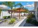 Beautifully landscaped backyard with a wooden pergola, a seating area, and a pathway for serene outdoor enjoyment at 37673 Dixie Ave, Dade City, FL 33525