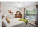 Bright bedroom with a ceiling fan, decorative wooden accents, and large window providing abundant natural light at 37673 Dixie Ave, Dade City, FL 33525