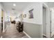 Long hallway with wood-look flooring, wall trim, and decorative pictures hung on the wall at 37673 Dixie Ave, Dade City, FL 33525