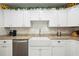 Close-up of a modern kitchen with stainless steel dishwasher and white farmhouse sink at 37673 Dixie Ave, Dade City, FL 33525