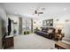 Cozy living room with plush leather sofa, ceiling fan, and large windows at 37673 Dixie Ave, Dade City, FL 33525