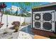 A charming shed with a white door and decorative accents, surrounded by meticulous landscaping and a white fence at 37673 Dixie Ave, Dade City, FL 33525