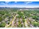 Wide aerial view of a tree-lined neighborhood with glimpses of the ocean and city skyline in the distance at 4105 W Bay Villa Ave, Tampa, FL 33611