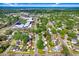 Aerial view of a residential area showcasing a house with a pool, mature trees, and nearby amenities at 4105 W Bay Villa Ave, Tampa, FL 33611