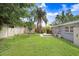 Expansive backyard with a well-maintained lawn, shed, privacy fence, and access to a deck at 4105 W Bay Villa Ave, Tampa, FL 33611