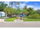 Charming home featuring a landscaped front yard, complemented by a bright blue door and vibrant green foliage at 4105 W Bay Villa Ave, Tampa, FL 33611