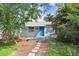Quaint home showcasing a blue front door and well-maintained landscaping in front at 4105 W Bay Villa Ave, Tampa, FL 33611