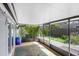 Enclosed patio featuring a ceiling fan, screens, and access to a lush backyard with garden at 4105 W Bay Villa Ave, Tampa, FL 33611