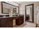 Well-lit bathroom features double sinks, granite counters, dark wood cabinets, and neutral tile at 4230 Hartwood Ln, Tampa, FL 33618