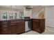 Kitchen featuring dark wood cabinetry, granite countertops and stainless-steel dishwasher at 4230 Hartwood Ln, Tampa, FL 33618