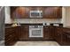 A kitchen is shown with dark cabinets, stainless steel appliances and tiled backsplash at 4230 Hartwood Ln, Tampa, FL 33618