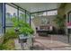 Inviting screened patio featuring comfortable seating, plants, and a brick floor, perfect for outdoor living at 4230 Hartwood Ln, Tampa, FL 33618