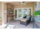 Relaxing covered patio featuring a comfortable wicker chair, ceiling fan, and outdoor decor at 4230 Hartwood Ln, Tampa, FL 33618