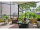 Relaxing screened-in patio with comfortable furniture and lush greenery, creating a serene outdoor oasis at 4230 Hartwood Ln, Tampa, FL 33618
