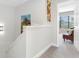 Upstairs hallway leading to a bedroom with a chair and art adorning the walls at 4306 Sunray Ct, Tampa, FL 33615