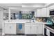 Modern kitchen features white cabinets, quartz countertops, stainless steel appliances, and an elegant chandelier at 4306 Sunray Ct, Tampa, FL 33615