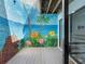 Charming patio enhanced by a vibrant, hand-painted tropical-themed mural at 4306 Sunray Ct, Tampa, FL 33615