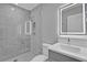 Modern bathroom featuring a glass shower with tile surround and a vanity with a lighted mirror at 455 Pinellas Bayway S # 4A, Tierra Verde, FL 33715