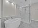 Modern bathroom showcasing a standalone tub and glass-enclosed shower with marble-style tile and fixtures at 455 Pinellas Bayway S # 4A, Tierra Verde, FL 33715