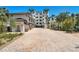 Elegant building featuring a long brick driveway with tropical landscaping and convenient covered parking at 455 Pinellas Bayway S # 4A, Tierra Verde, FL 33715