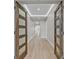 Bright hallway featuring stylish wood-look floors, modern lighting, and elegantly paneled wood doors at 455 Pinellas Bayway S # 4A, Tierra Verde, FL 33715