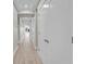Well-lit hallway with wood-look floors, recessed lighting, and neatly lined white doors at 455 Pinellas Bayway S # 4A, Tierra Verde, FL 33715