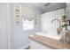 Bright bathroom featuring a white vanity, round mirror, shower curtain, and hanging plants at 5129 Se Salmon Se Dr # A, St Petersburg, FL 33705