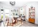 Bright dining area features a modern light fixture, white table, neutral chairs and natural light at 5129 Se Salmon Se Dr # A, St Petersburg, FL 33705